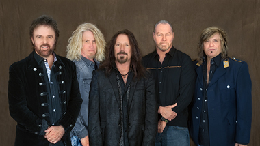 38 Special posing in front of a brown, textured background.