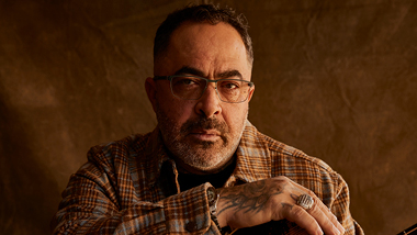 Aaron Lewis wearing flannel with brown background