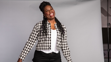 Leslie Jones in plaid shirt with screen background
