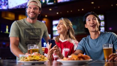 People on their phone at the sportsbook with food