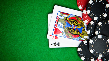 An Ace and a Jack layed out in front of several chips on a green card table