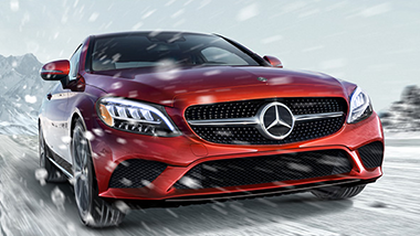 Red Mercedes driving in the snow