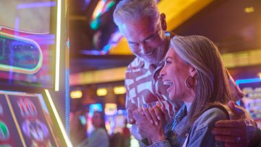 Man and Woman playing at a slot machine